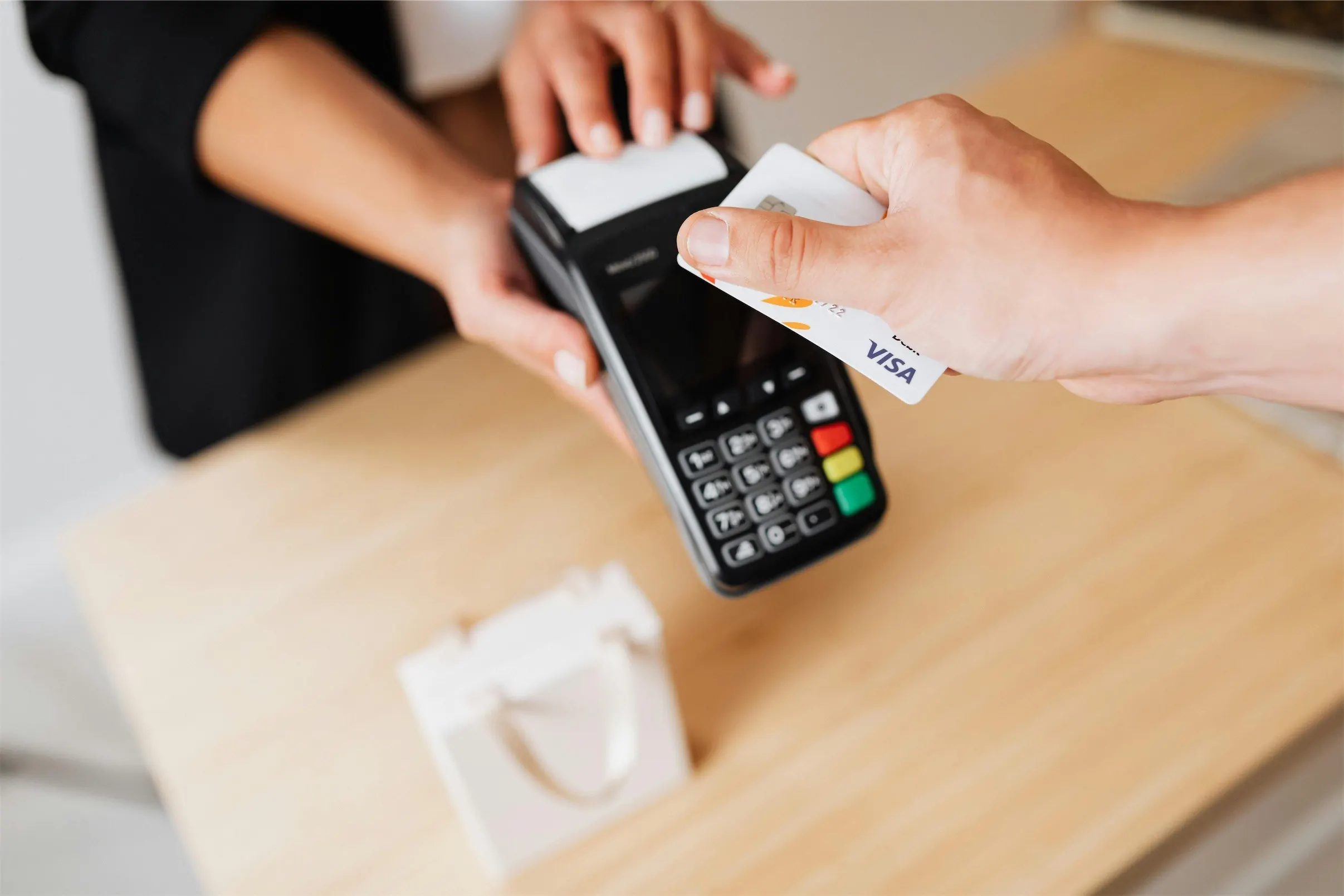 Customer paying by card at checkout, sales from paid media ads